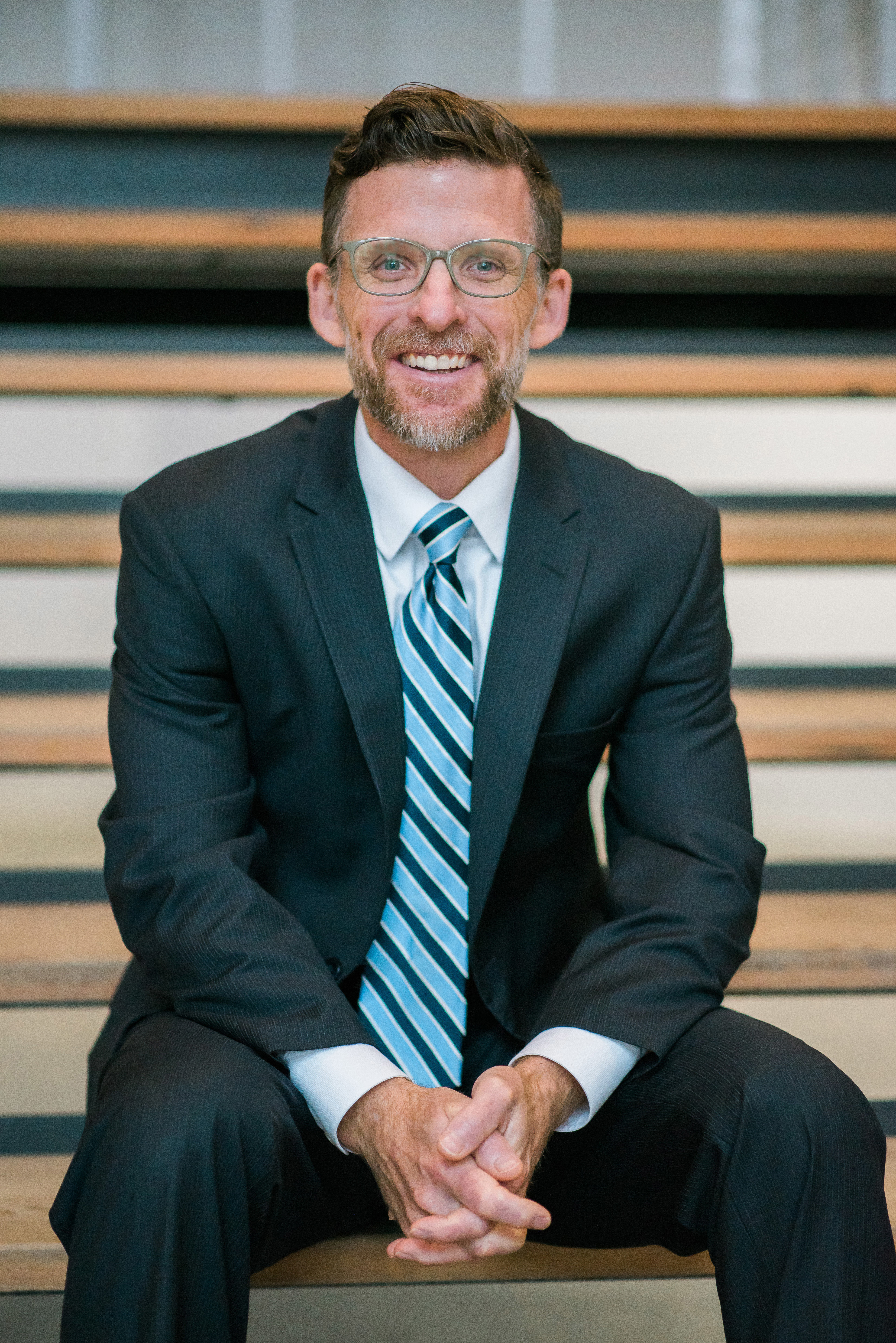 CEO David Hilyer sitting on steps while smiling.